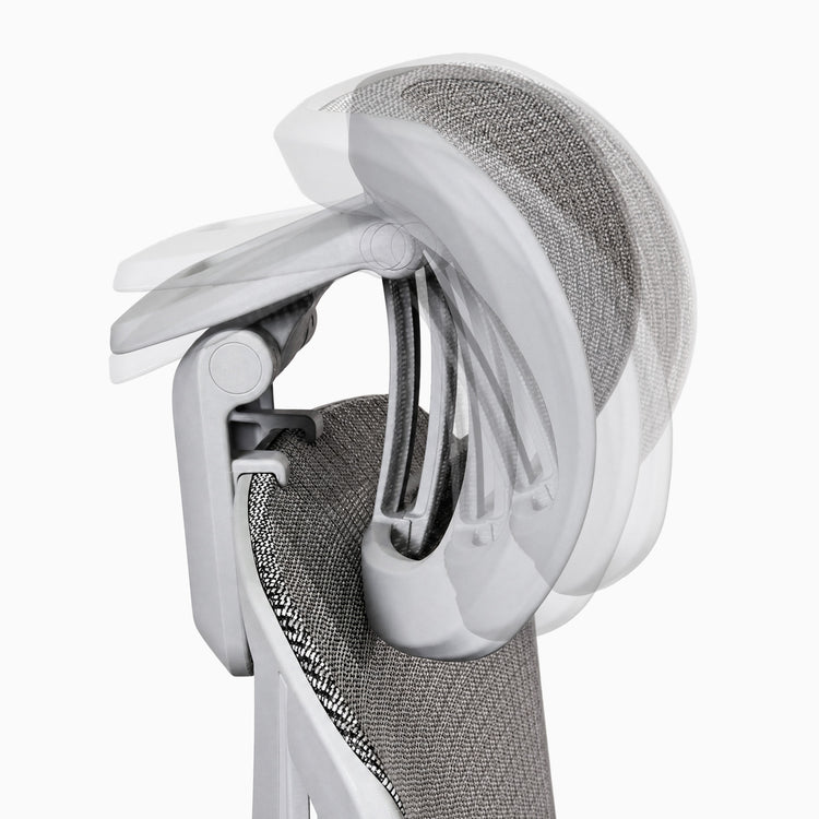 Gros plan sur une chaise de bureau ergonomique montrant l'appui-tête et le cadre blanc, sur fond gris clair.